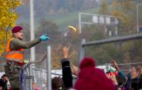 [фото-документалистика] Австрийский полицейский бросает банан беженцам